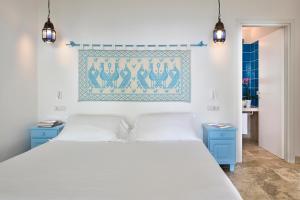 a bedroom with a white bed and blue cabinets at Arbatax Park Resort - Ville del Parco in Àrbatax +50 photos