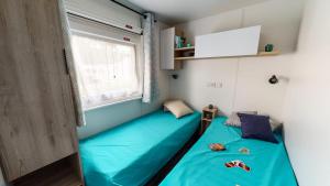 a room with two beds and a window at Mobil-home 6 pers, tout confort Clim, piscine & animations in Agde