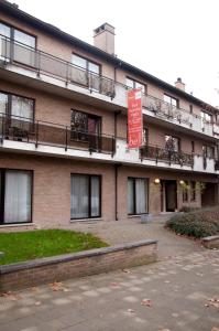 a large brick building with a sign in front of it at Budget Flats Brussels in Brussels