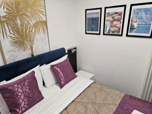 a bedroom with a bed with purple and white pillows at Grande Bellezza Luxury Suite in Mestre