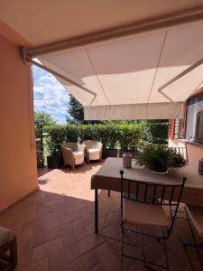 un patio con tavolo, sedie e ombrellone di Le case di Anita in Toscana - Arezzo ad Arezzo