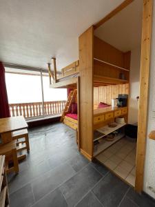a room with two bunk beds and a table at Dome De Polset Condo by AlpStays in Val Thorens +10 photos