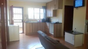 a living room with a couch and a kitchen at 33 On Swallows Guest House in Soshanguve