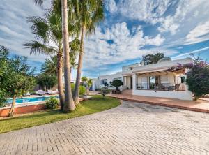 a villa with a swimming pool and palm trees at Villa Can Petrus, con piscina y wifi gratis in San Antonio Bay