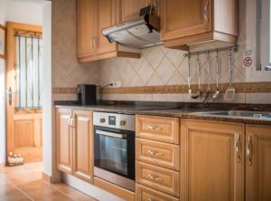 a kitchen with wooden cabinets and a stove top oven at Villa Can Petrus, con piscina y wifi gratis in San Antonio Bay