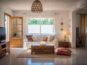a living room with a white couch and a table at Villa Can Petrus, con piscina y wifi gratis in San Antonio Bay