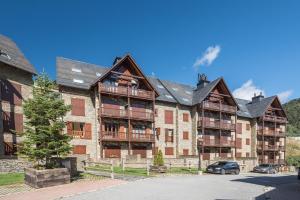 an apartment building with cars parked in front of it at Roca Blanca by Totiaran in Naut Aran