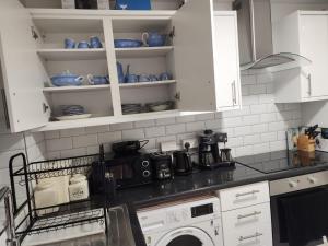 a kitchen with white cabinets and a washing machine at Dmltd in Northampton +5 photos