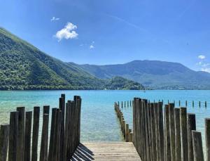 a view of a lake with a wooden pier at Élégance au Bord de l'Eau in Aiguebelette-le-Lac