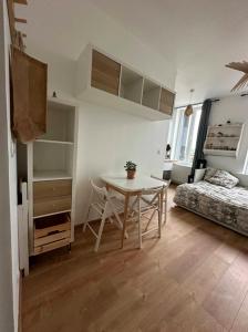 a room with a table and a bed and a bedroom at Élégance au Bord de l'Eau in Aiguebelette-le-Lac