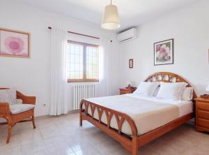 une chambre avec un grand lit et une chaise dans l'établissement Casa para familias en Ibiza, à Bahía de Sant Antoni