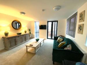 ein Wohnzimmer mit einer grünen Couch und einem Tisch in der Unterkunft Ranmoor Serviced Apartments at Wilkinson Lane- The Burlington Suite in Sheffield