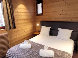 ein Schlafzimmer mit einem Bett mit zwei Handtüchern darauf in der Unterkunft Appartement rénové, proche pistes, balcon, 3 chambres, parking, Wifi inclus - FR-1-598-132 in Les Gets