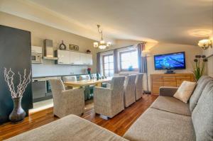 cocina y sala de estar con sofá y sillas en Select Top 10 - by Alpen Apartments, en Piesendorf
