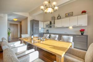 Una cocina y un comedor con mesa y sillas de madera. en Select Top 10 - by Alpen Apartments, en Piesendorf