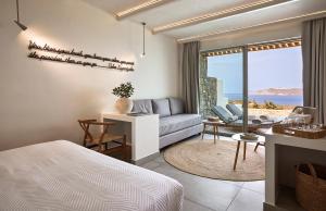 a bedroom with a bed and a living room at Hotel Milos Sea Resort in Adamantas