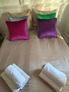 a bed with two pillows and two towels on it at Cosy by Mandy in Amsterdam