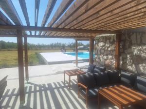 a patio with a couch and a table and a pool at Pepi Sobe in Čepin