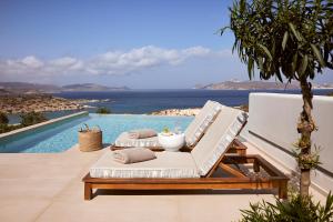 a lounge chair sitting next to a swimming pool at Hotel Milos Sea Resort in Adamantas