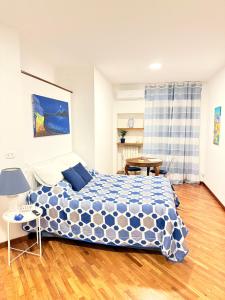 Un dormitorio con una cama con un edredón azul y blanco. en Mamà Vesuvius Home, en Portici