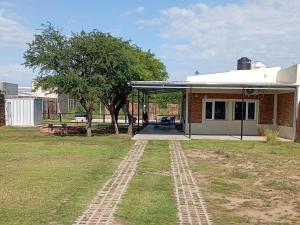 ein Haus mit einem Feldweg im Hof in der Unterkunft CASA quinta ""LUZ AZUL"" con pileta, galeria, calefaccion , doble aire frío calor, WIFI in Santa Rosa