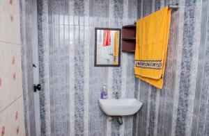 a bathroom with a sink and a yellow towel at The Fika Casa Home Stay in Meenangadi +27 photos