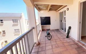 una bicicleta estacionada en un balcón con TV en The Sunset Catcher - Langebaan, en Langebaan