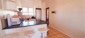 cocina con 2 aseos y encimera con microondas en The Sunset Catcher - Langebaan, en Langebaan
