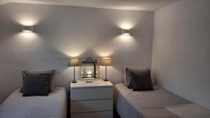 een kamer met 2 bedden, een spiegel en verlichting bij Carmen Casa Helena in Nerja