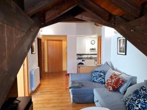 a living room with a blue couch and a kitchen at El Rincón de las Estrellas in Escarrilla