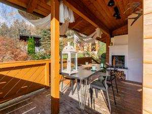 a patio with a table and chairs on a wooden deck at TraumLodge in Kleinsonnberg