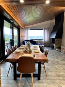 ein Esszimmer mit einem langen Holztisch und Stühlen in der Unterkunft La Maison des Trois Arbres in Malmedy