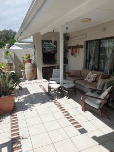 a patio with a couch and chairs on a house at Paradise in Plettenberg Bay in Plettenberg Bay +3 photos