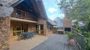a house with a deck with a table and chairs at Kruger Park Lodge - Unit 522 , Hazyview in Hazyview