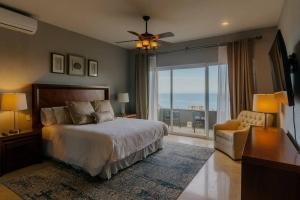 a bedroom with a bed and a view of the ocean at Casa de las Olas - Villa Ocean View in San José del Cabo