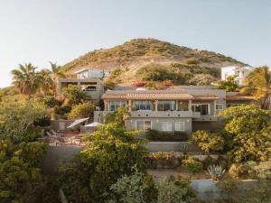 a large house in front of a hill with trees at Casa de las Olas - Villa Ocean View in San José del Cabo