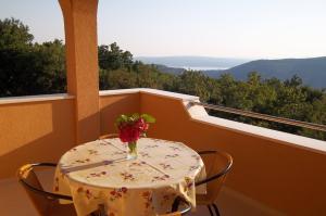 a table with a vase of flowers on a balcony at Villa Kapitulac in Grižane