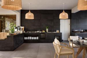 a restaurant with black walls and a table and chairs at Hotel Milos Sea Resort in Adamantas