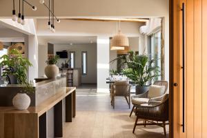 a kitchen and living room with chairs and plants at Hotel Milos Sea Resort in Adamantas