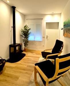 Una sala de estar con dos sillas y una chimenea. en San Xuan Resort, en San Juan de Nieva 12 fotos más