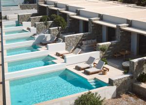 an image of a swimming pool with lounge chairs and a building at Hotel Milos Sea Resort in Adamantas