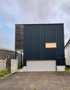 a large black building with a white garage at Echo Lodge in Kutchan
