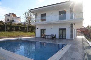 a house with a swimming pool in front of a house at Garden Hill Villa Durres in Durrës
