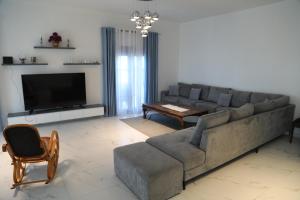a living room with a couch and a television at Garden Hill Villa Durres in Durrës