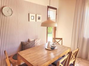 a dining room table with chairs and a clock on the wall at Baltrumweg 4 in Wangerland