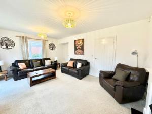 a living room with two leather couches and a table at Stay for business, corporate, contractors or leisure with private parking in Ashford