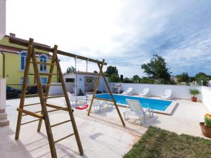 un parque infantil con un columpio y una piscina en Villa Patricia, en Štinjan