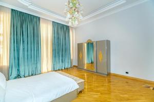 バクーにあるMalakan Nizami City Hotel Baku And Apartments Familyのベッドルーム1室(ベッド1台、青いカーテン、シャンデリア付) +212枚の写真