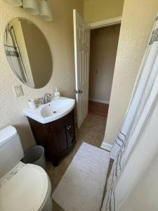a bathroom with a toilet and a sink and a mirror at Maison Pierre in Jacksonville