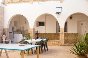 een patio met tafels en stoelen en een basketbalring bij Dar Othmen in Tozeur